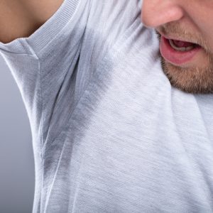 Close-up Of A Man In Grey T-shirt Looking At His Sweaty Armpit